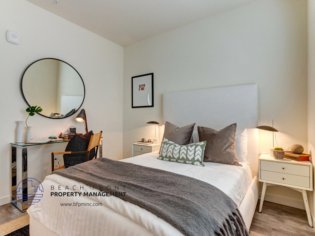 a bedroom with a bed and a desk and a mirror