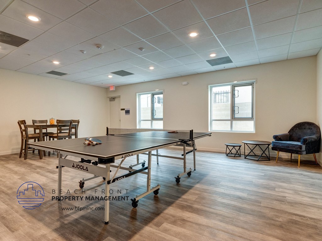 a game room with a ping pong table and chairs