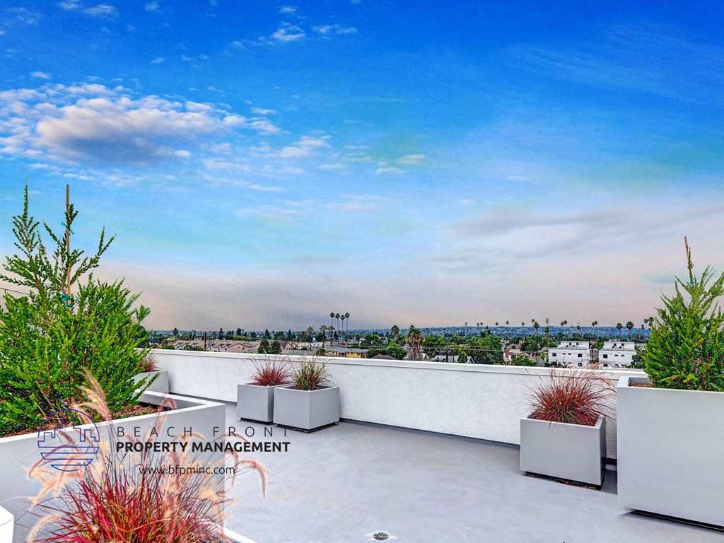 a roof terrace with a view of the city and the sky