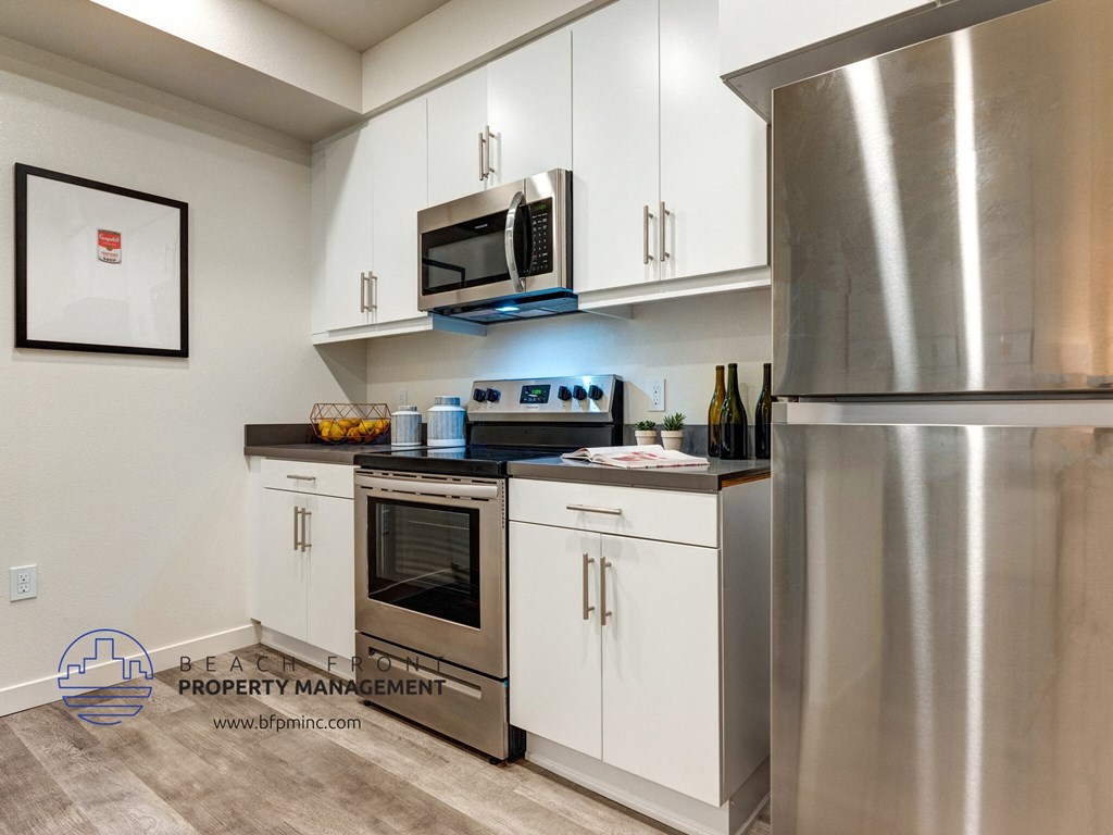 a small kitchen with stainless steel appliances and white cabinets