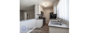 A kitchen with a sink, stove, and refrigerator.