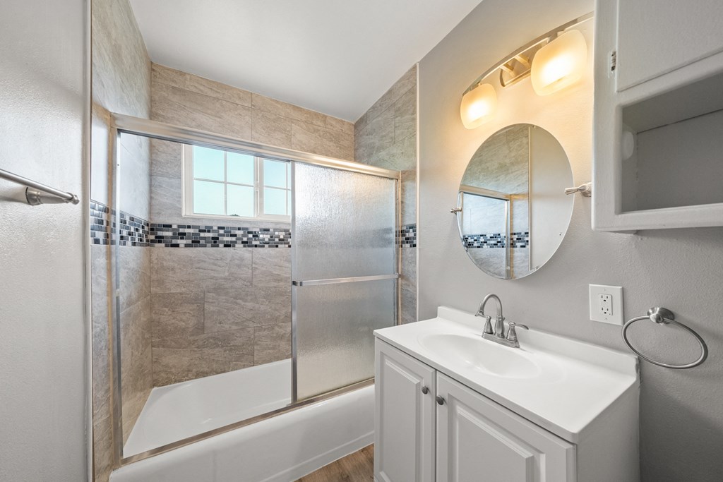 a bathroom with a sink and a shower and a mirror