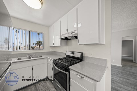 A kitchen with a stove top oven and a sink.
