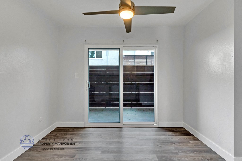 the living room of an empty apartment with a ceiling fan
