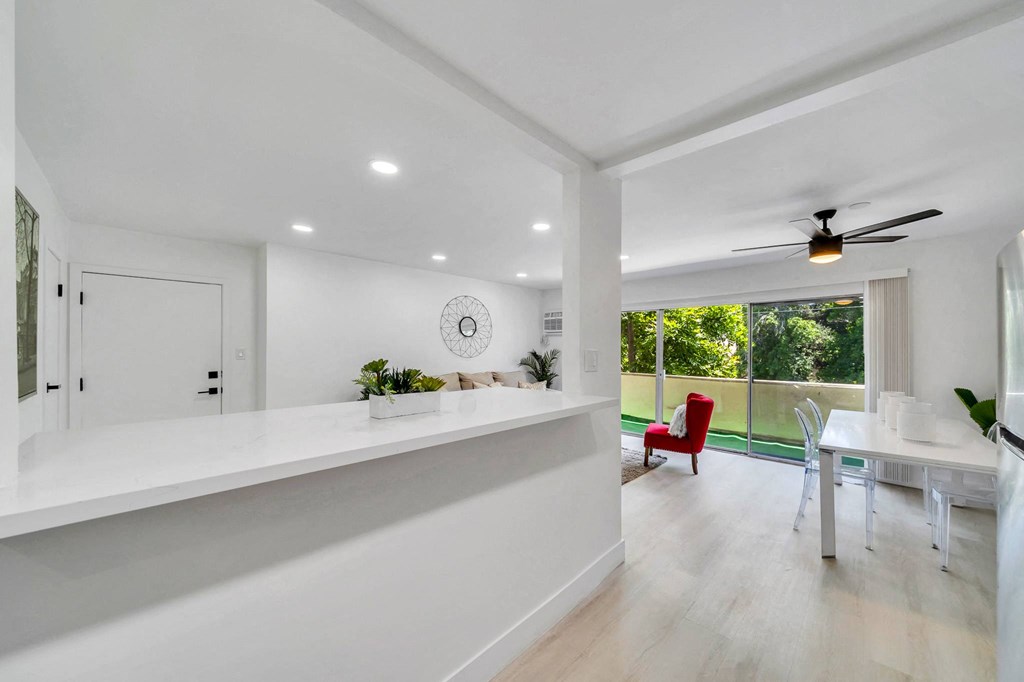 a white kitchen with a counter and a table with chairs