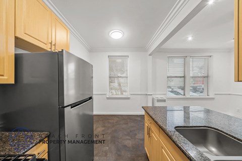 a kitchen with granite counter tops and a stainless steel refrigerator