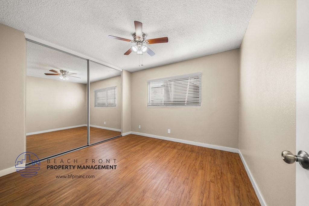 the living room of a home with a wood floor and a ceiling fan