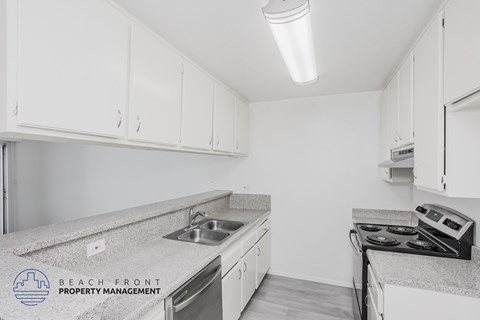 A kitchen with white cabinets and a granite countertop.