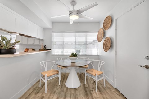 A white dining room with a table and chairs.