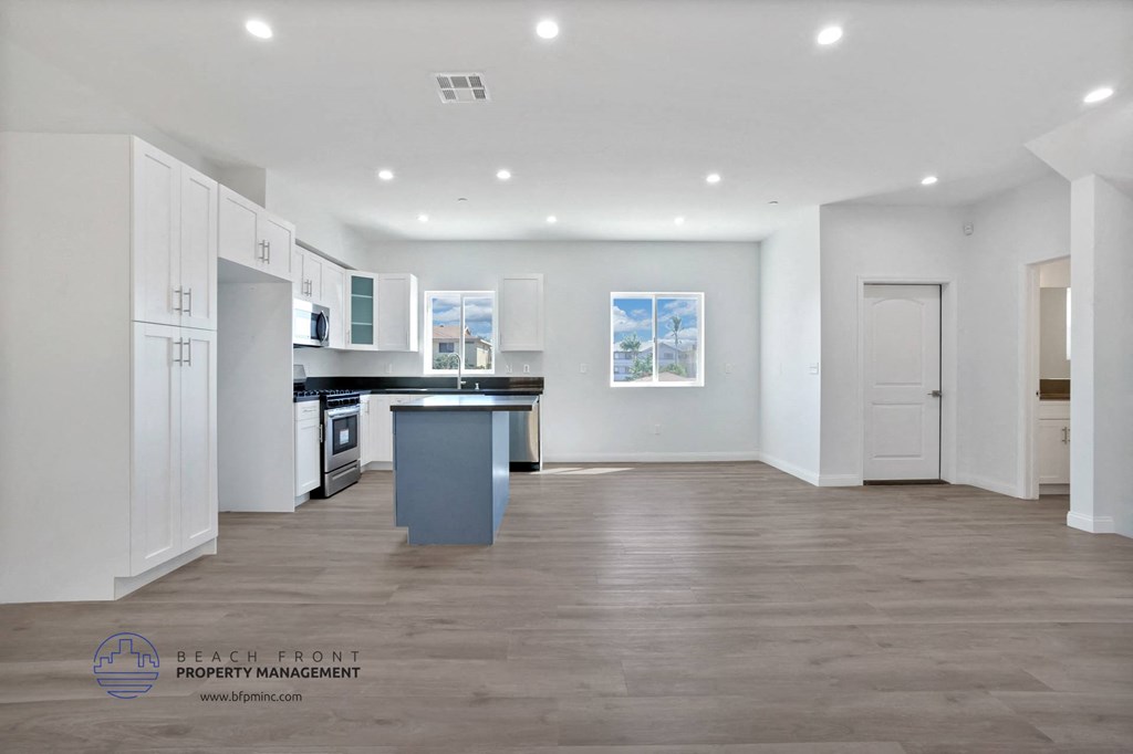 a white kitchen with white cabinets and a black counter top
