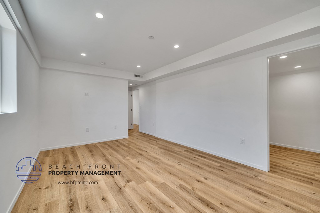 a living room with white walls and wood flooring