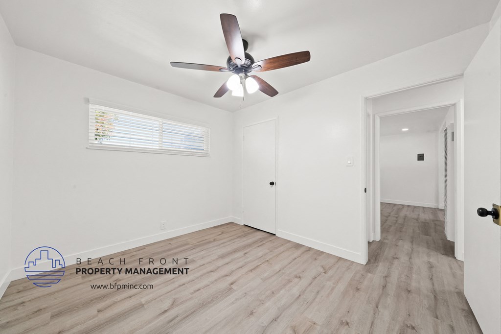 a bedroom with hardwood flooring and a ceiling fan