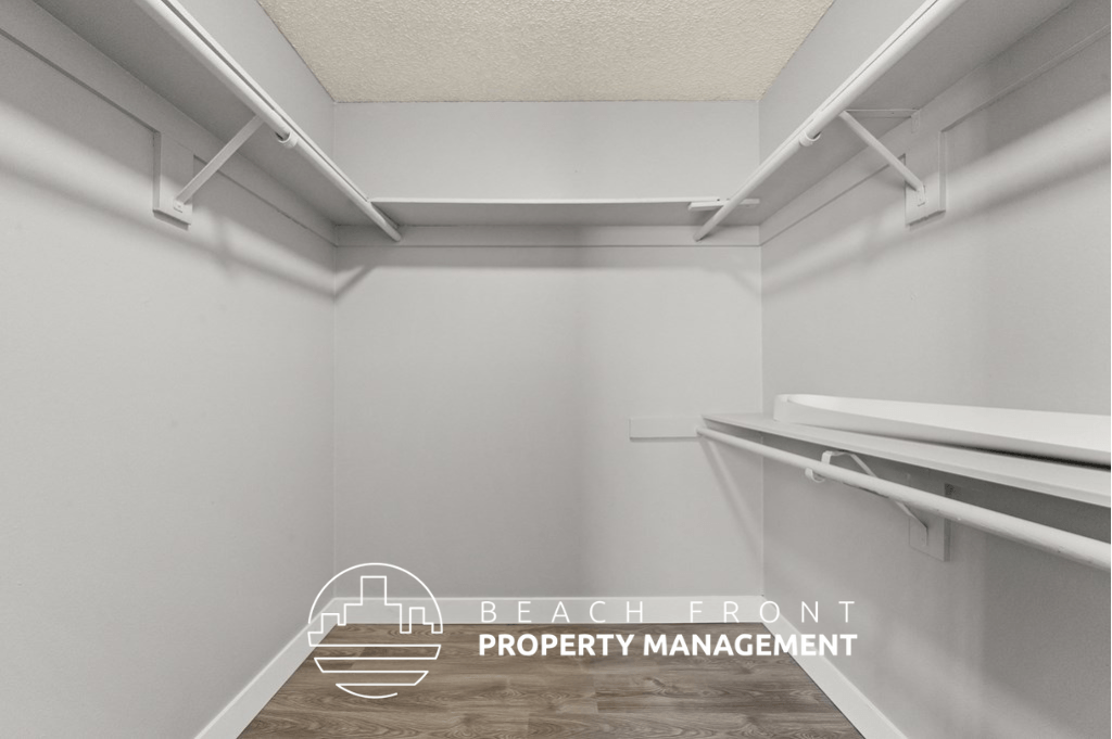 a walk in closet with white walls and a white rack on the wall with a