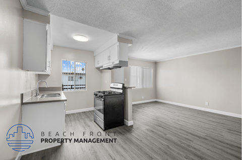 a kitchen with white cabinets and a stove top oven and a sink