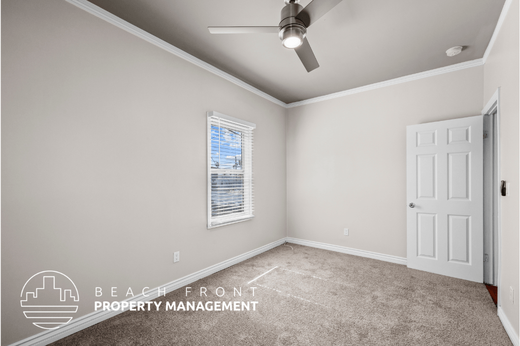 an empty room with a ceiling fan and a white door