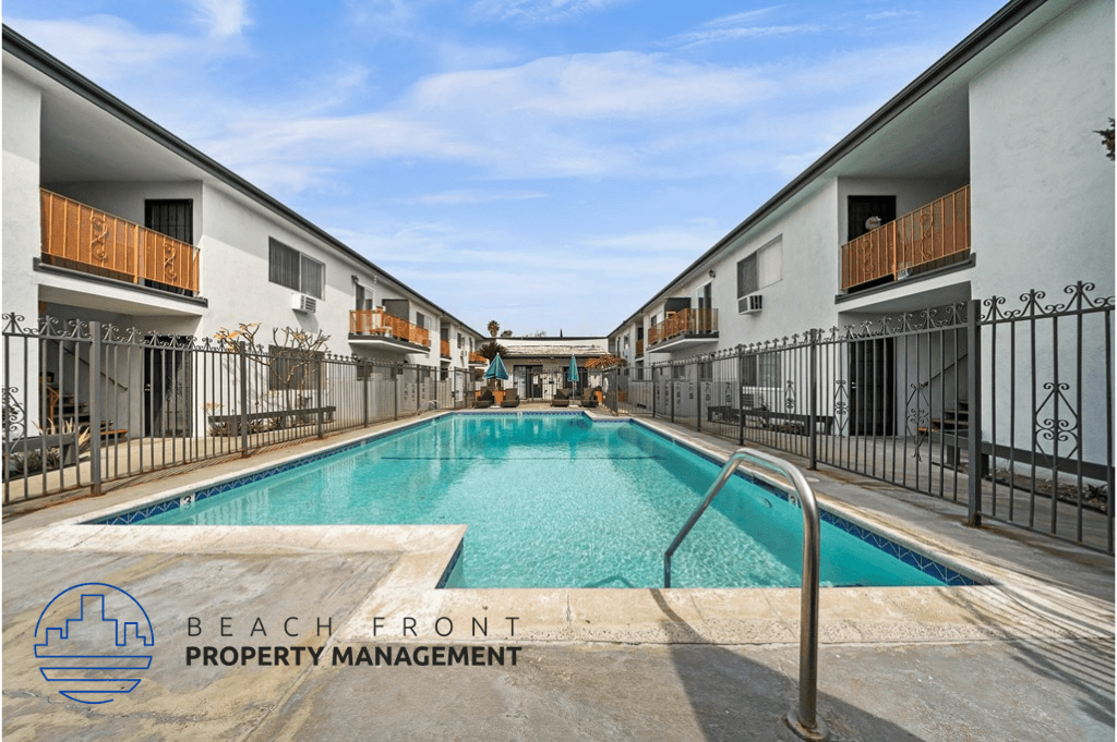 a swimming pool in the middle of two buildings with a fence