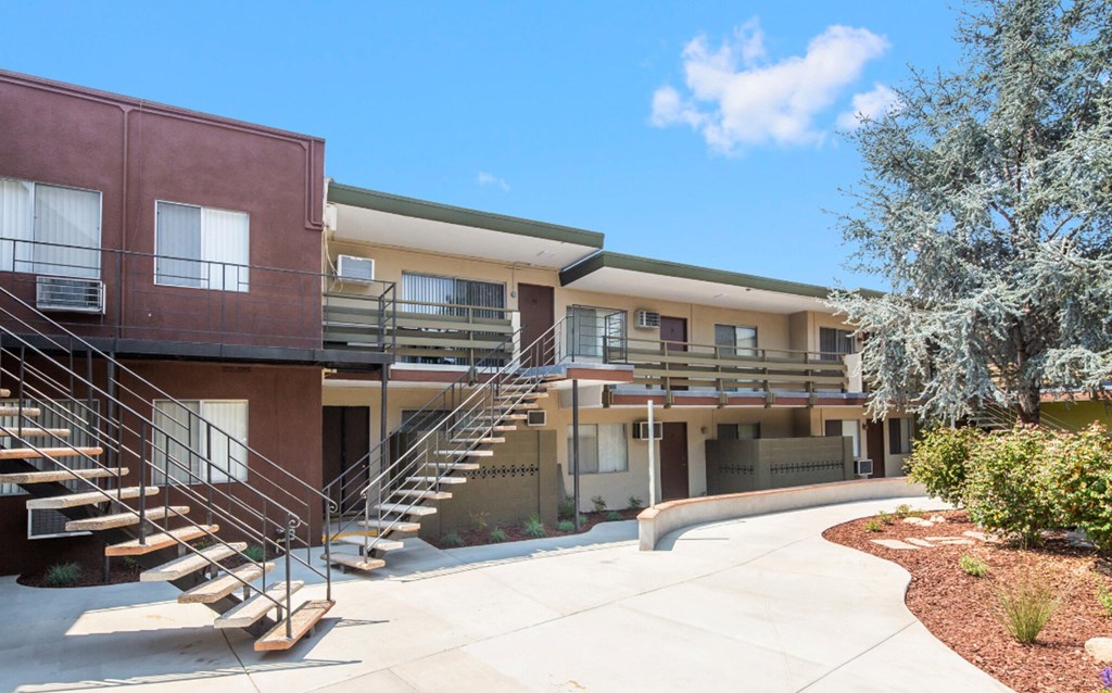 a building with stairs and a sidewalk in front of it