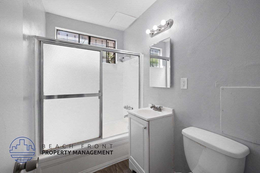 a bathroom with a shower and a toilet and a sink