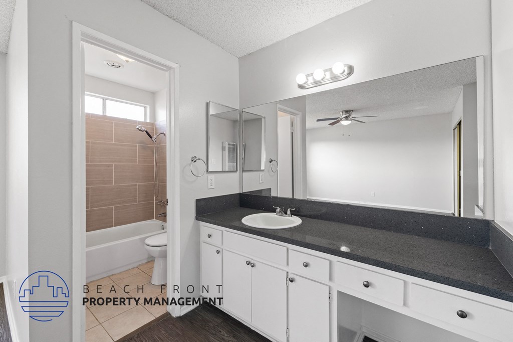 a bathroom with white cabinets and a sink and a mirror