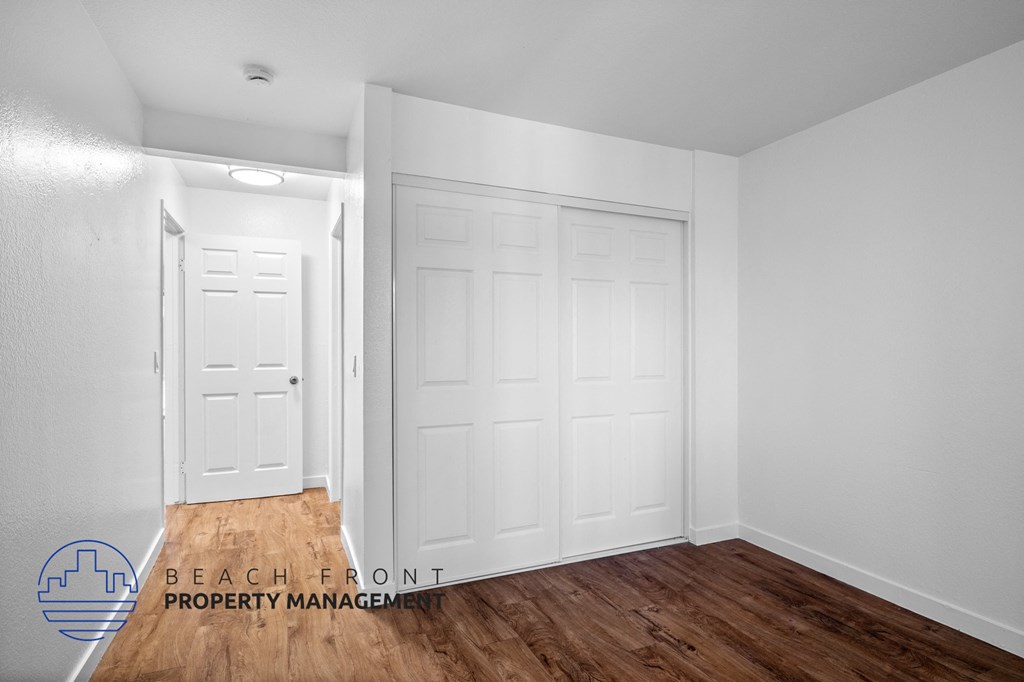 the living room of a house with two closets and a wood floor