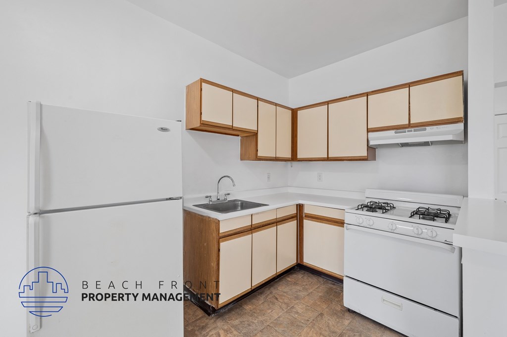 A kitchen with white appliances and wooden cabinets.