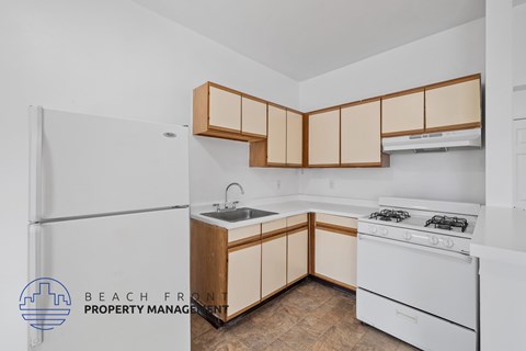 A kitchen with white appliances and wooden cabinets.