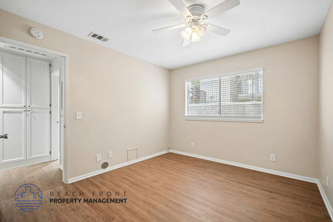 A room with a ceiling fan and a window with blinds.