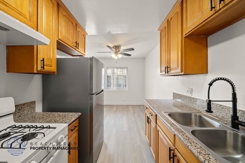 A kitchen with wooden cabinets and a black refrigerator.