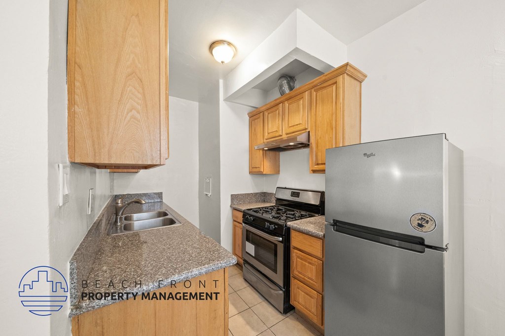 A kitchen with a granite counter top and stainless steel appliances.