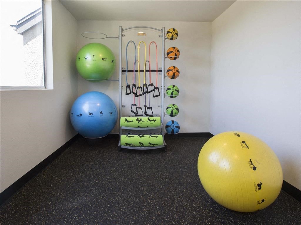a workout room with exercise balls and a rack