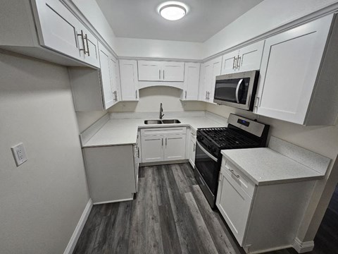 a kitchen with white cabinets and a black stove