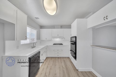 a white kitchen with white cabinets and white counter tops