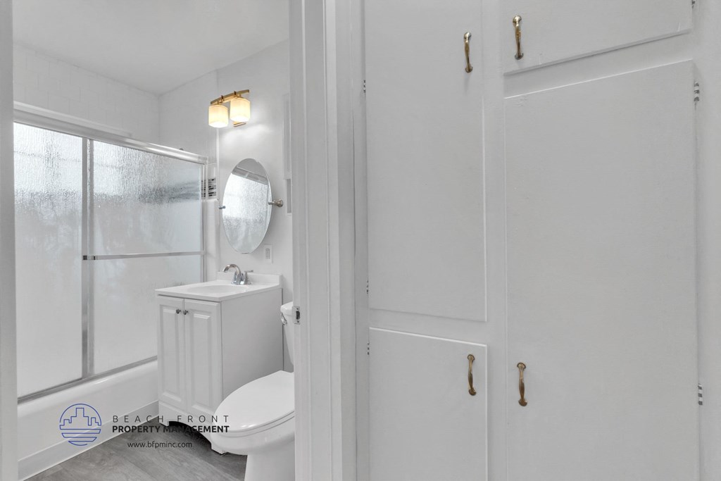 a bathroom with white cabinets and a white toilet