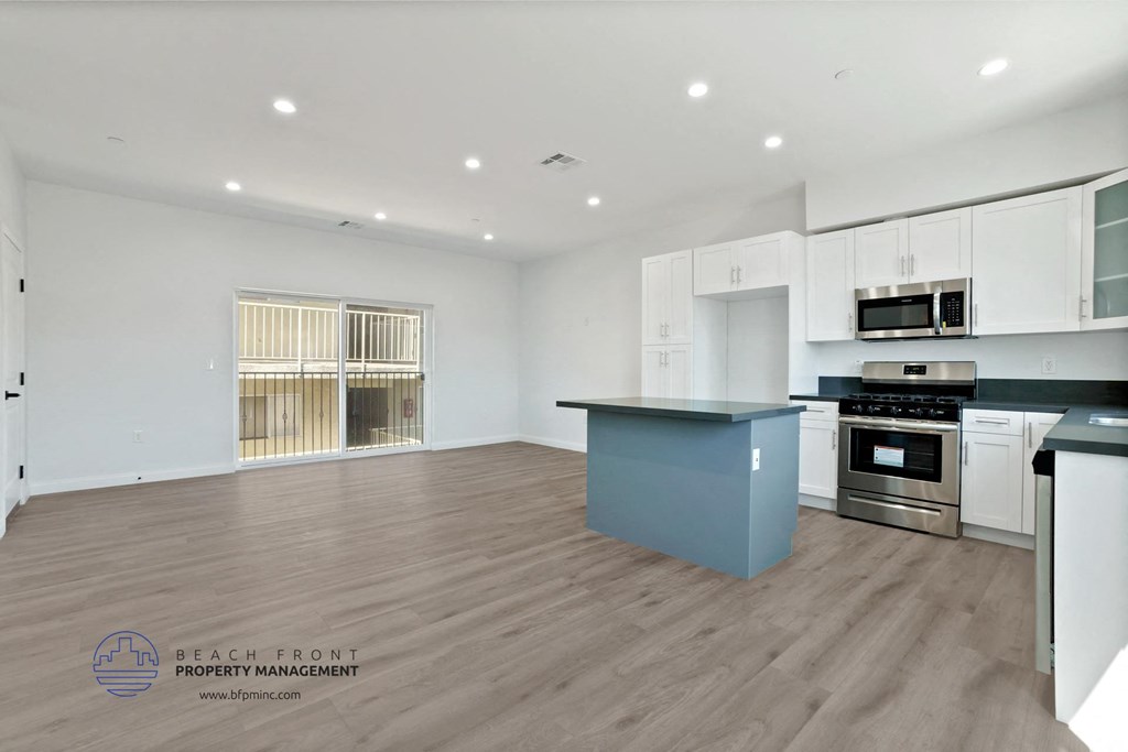 a white kitchen with a blue island in the middle