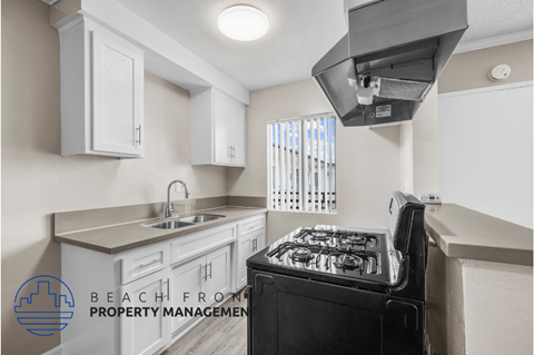 a kitchen with white cabinets and a stove and a sink