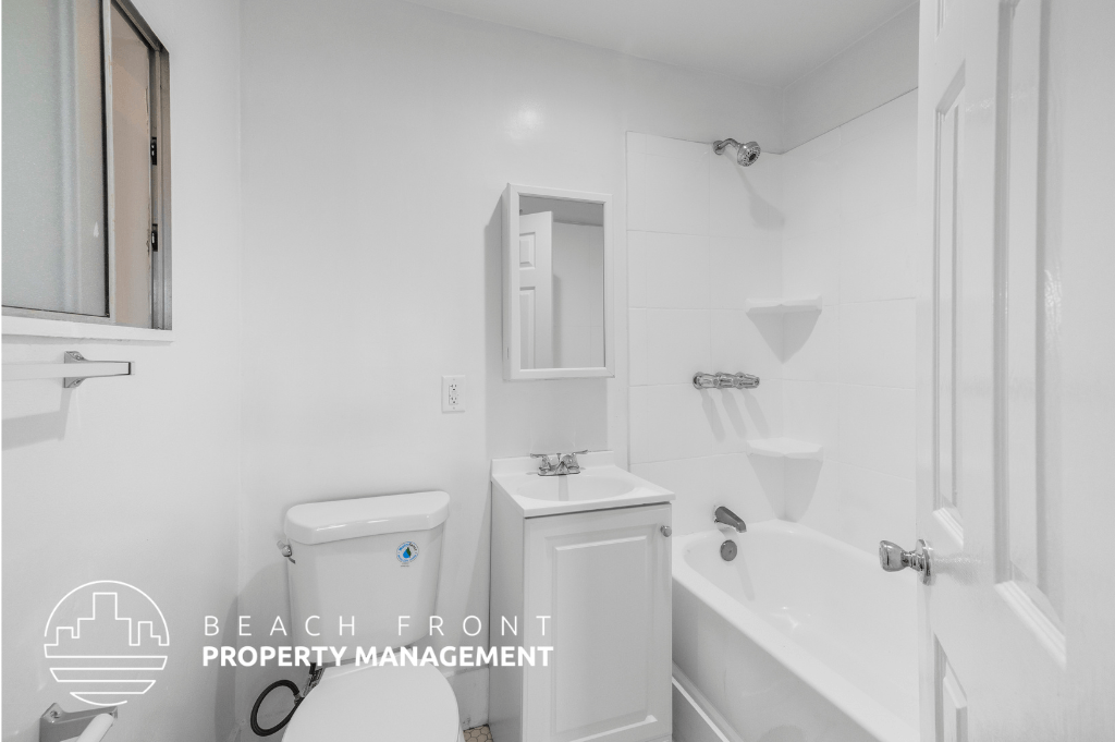 a white bathroom with a tub and a toilet and a sink