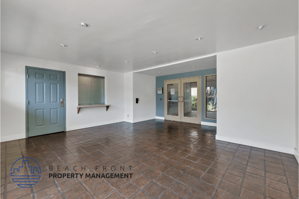 an empty living room with a blue door and a tile floor