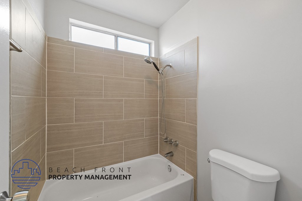 a bathroom with a tub and a toilet and a window