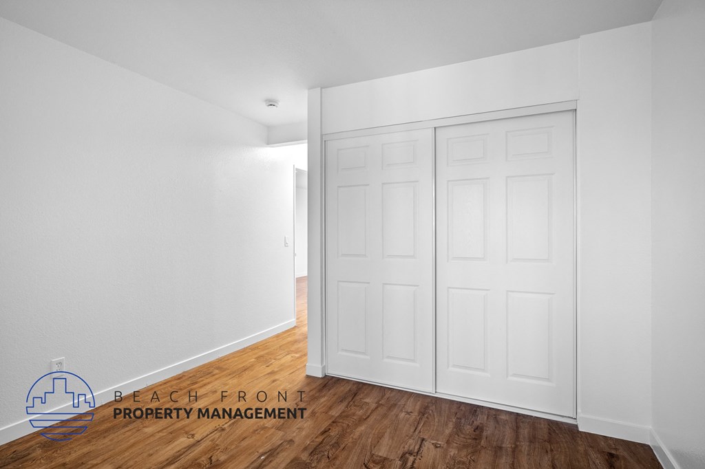 a bedroom with two closets and a wood floor
