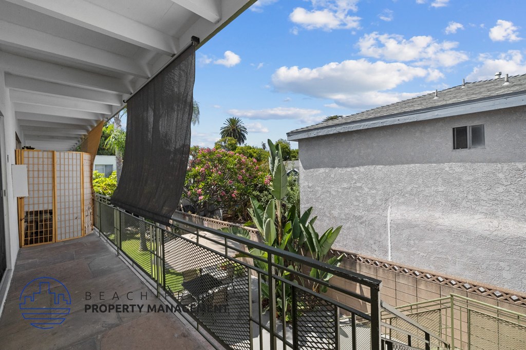 a balcony with a view of a house and a garden