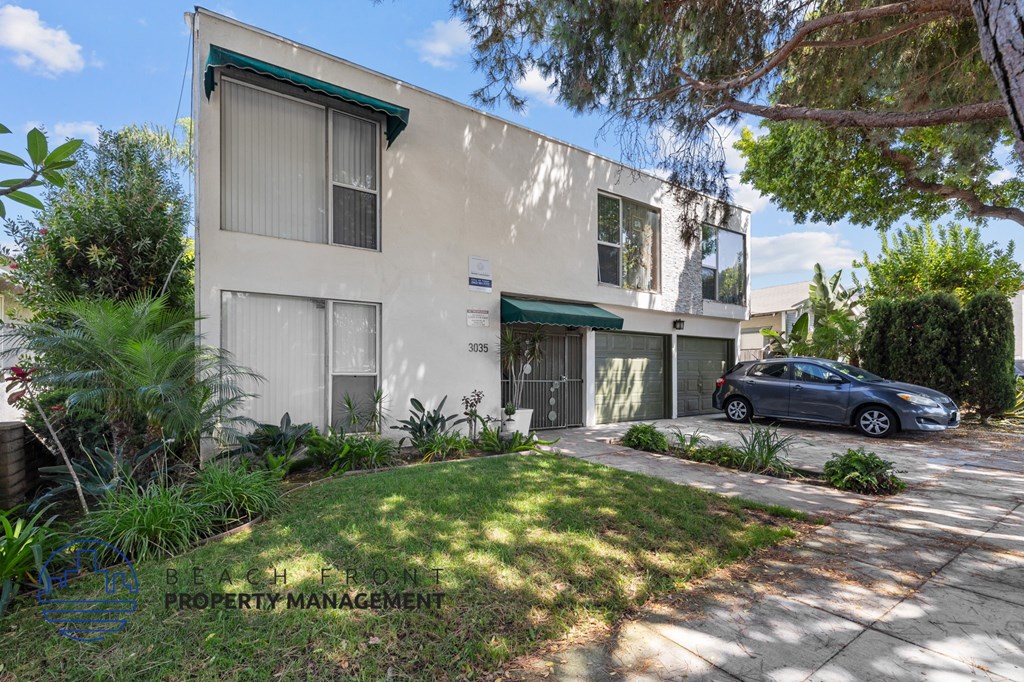 a white house with a car parked in the driveway