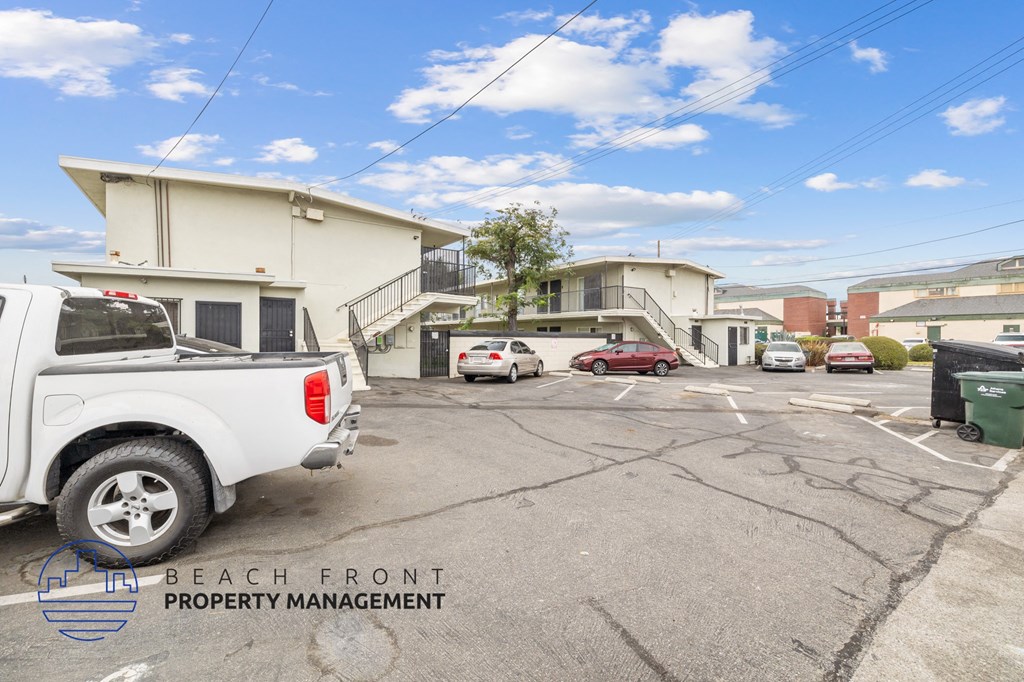 a white truck parked in a parking lot in front of buildings