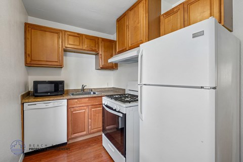 A kitchen with wooden cabinets and a white refrigerator.