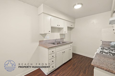 A kitchen with white cabinets and a granite countertop.