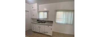 A kitchen with white cabinets and a granite countertop.