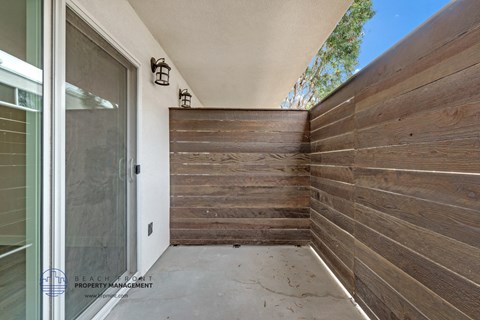 a fenced in area with a wooden fence and a glass door