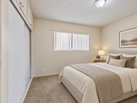 A bedroom with a large bed and a painting on the wall.