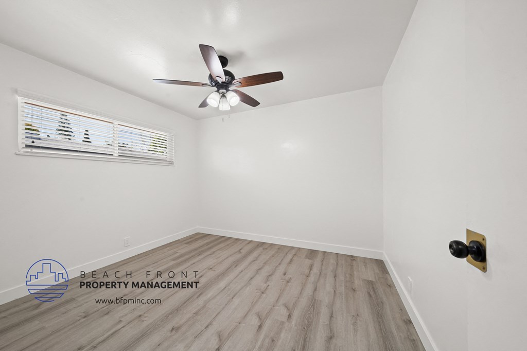 a bedroom with hardwood floors and a ceiling fan