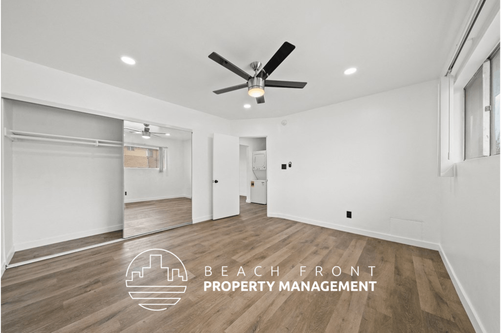 a living room with white walls and a ceiling fan
