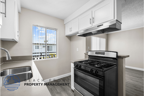 a kitchen with a stove and a sink and a window